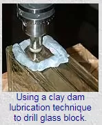using a clay dam lubrication technique to drill glass block